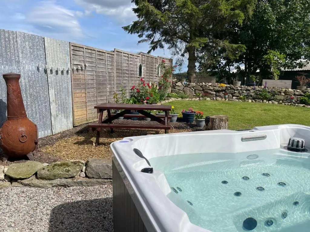 a bath tub in a yard with a picnic table at Barclay\u2019s But n Ben in Alford