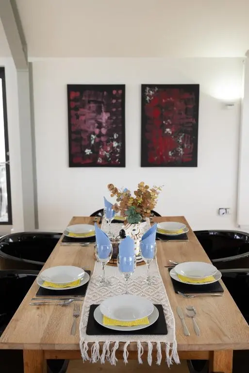a wooden table with plates and glasses on it at A Stunning State Of The Art Eco Home - Games Room in Westhill