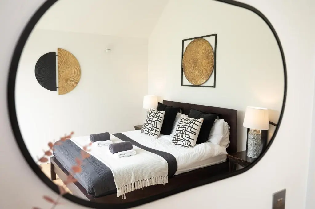 a bedroom with a bed with black and white pillows at A Stunning State Of The Art Eco Home - Games Room in Westhill