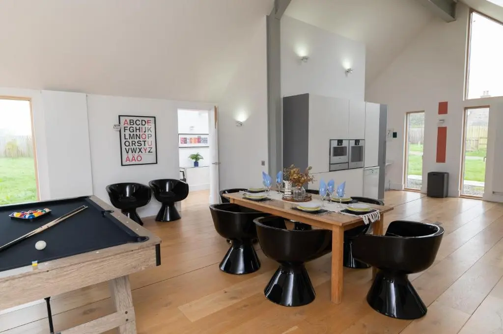a room with a pool table and some black chairs at A Stunning State Of The Art Eco Home - Games Room in Westhill