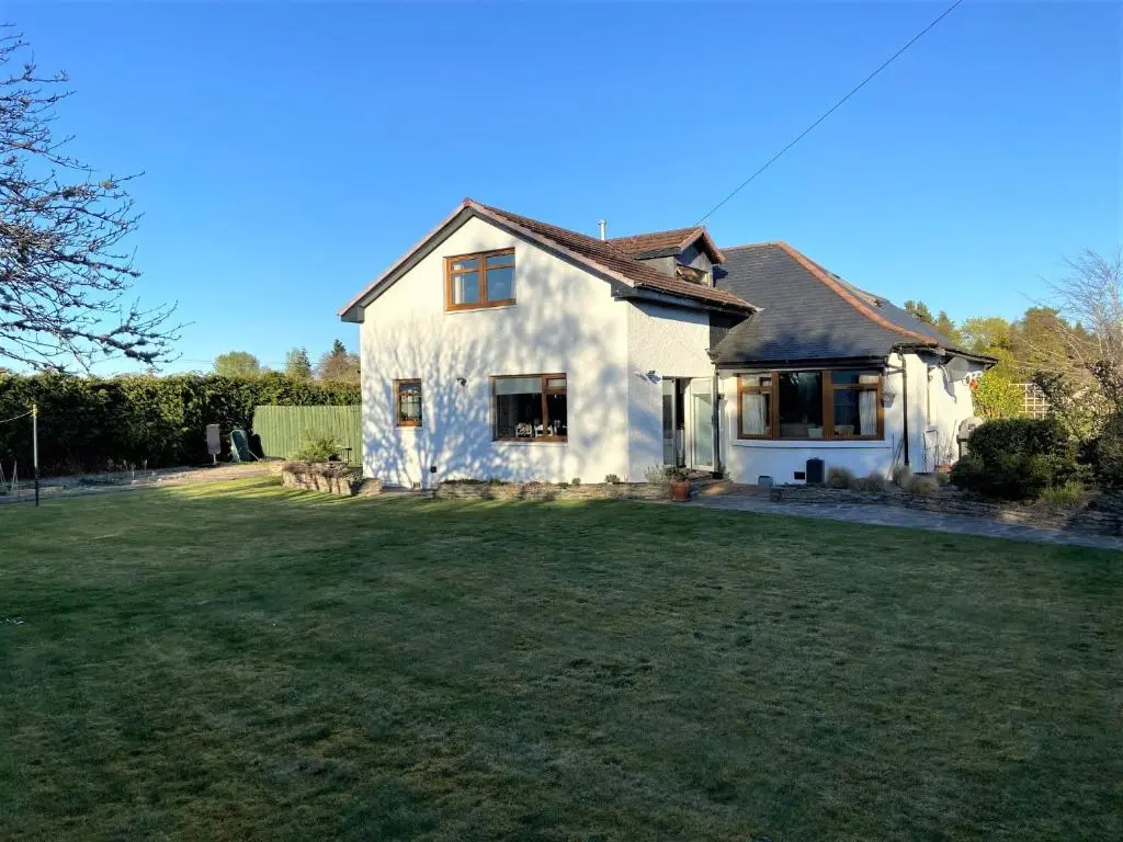 a white house with a large grass yard at Chalet on the Green - Self Contained with parking. in Inshes