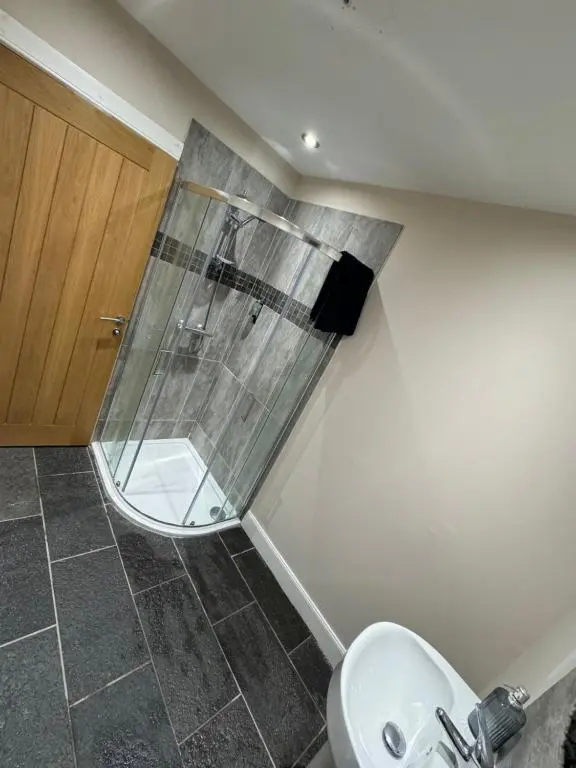 a bathroom with a shower and a toilet and a sink at Central 2 bedroom apartment in Wick