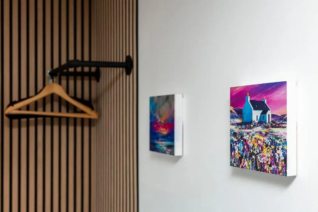 two pictures are hanging on a wall next to a door at Lochbroom Lodge in Ullapool