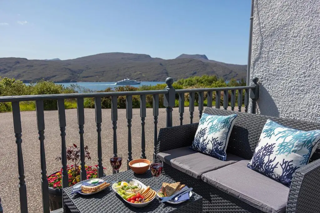 a patio with a couch and a table with food on it at Lochbroom Lodge in Ullapool
