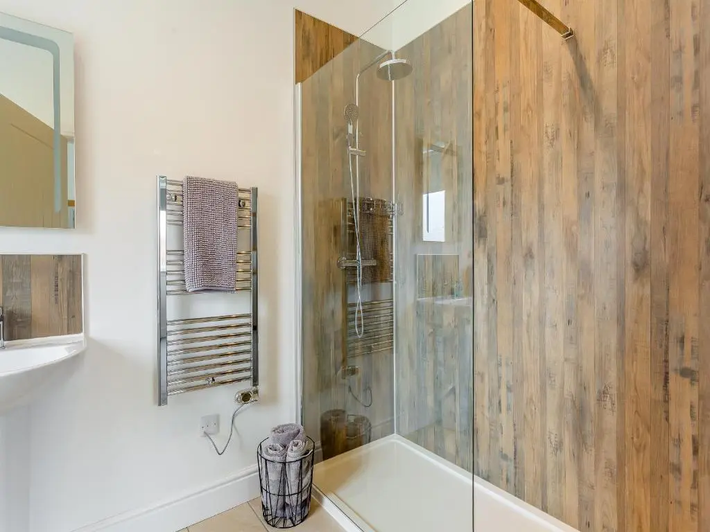 a bathroom with a shower with a glass door at Old School House in Altnaharra