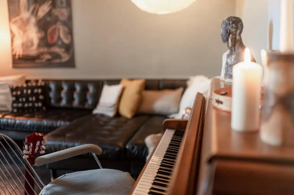 a living room with a couch and a piano at The Dell of Abernethy - A Woodland hideaway in Nethy Bridge