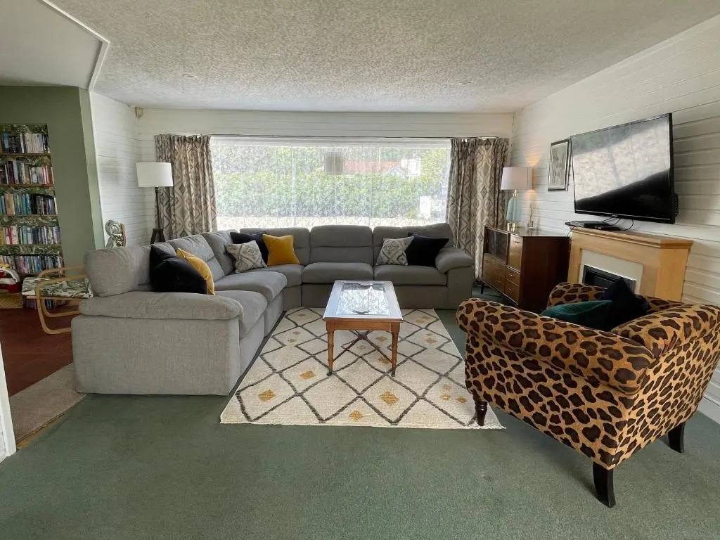 a living room with a couch and a tv at Spacious Sea View Home 5 miles from Inverness in North Kessock
