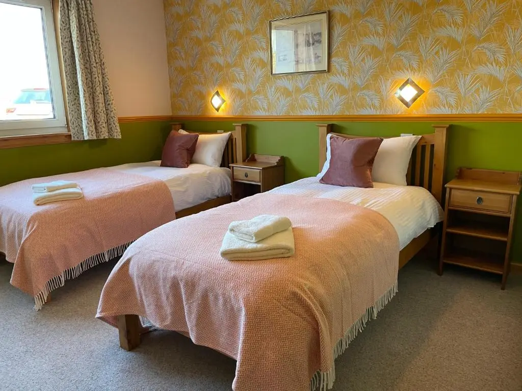 two beds in a room with green walls at Spacious Sea View Home 5 miles from Inverness in North Kessock