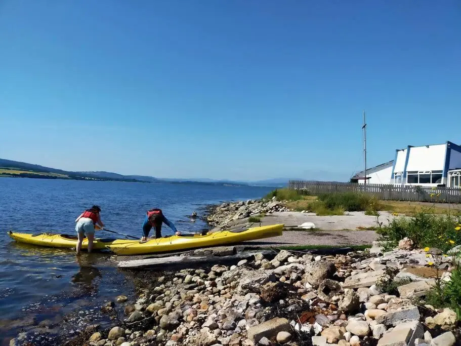 two people in kayaks in the water on a river at Spacious Sea View Home 5 miles from Inverness in North Kessock