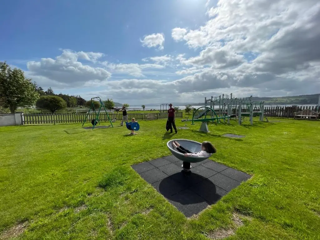 a park with a playground with a person in a bowl at Spacious Sea View Home 5 miles from Inverness in North Kessock