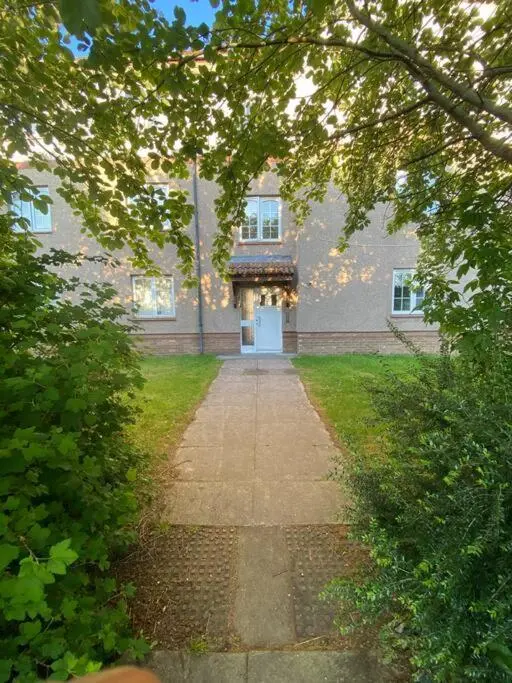 a large brick building with a white door in the middle at Apartment with parking, close to the Raigmore hospital in Inverness