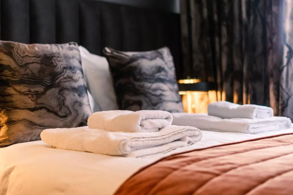 a pile of towels sitting on top of a bed at Sweeney Aviemore One in Aviemore