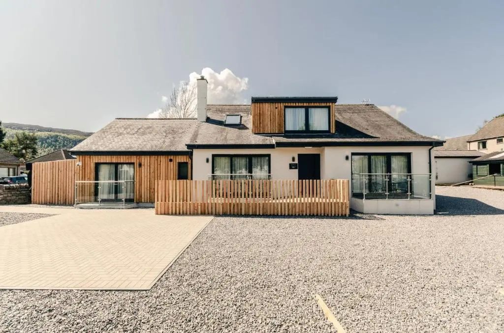 a house with a gravel driveway in front of it at Sweeney Aviemore One in Aviemore