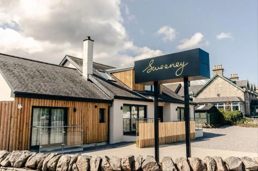 a sign for a restaurant in front of a building at Sweeney Aviemore One in Aviemore