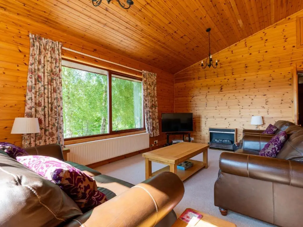 a living room with a couch and a table at Holiday Home Achmony Number 9 by Interhome in Drumnadrochit