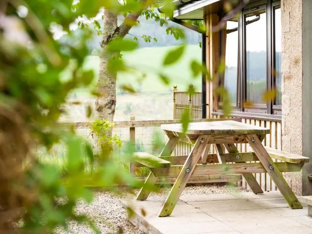 a picnic table on the porch of a house at Holiday Home Achmony Number 8 by Interhome in Drumnadrochit