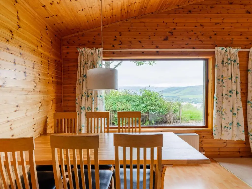 a dining room with a table and a large window at Holiday Home Achmony Number 8 by Interhome in Drumnadrochit