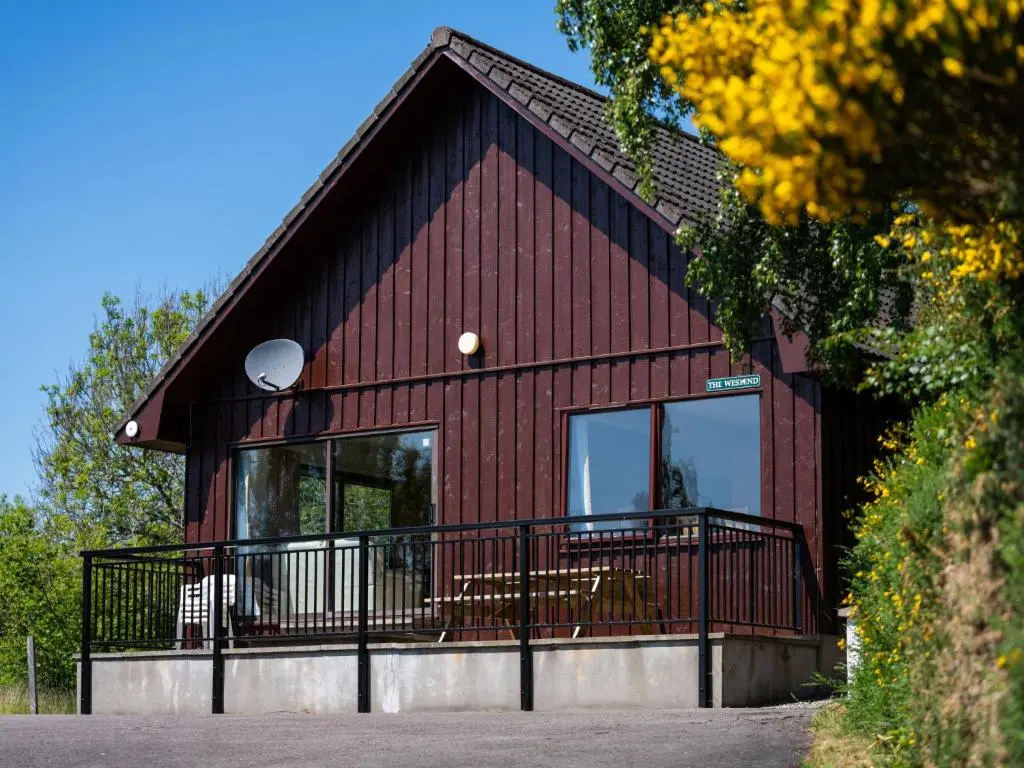 a red house with a black roof and windows at Holiday Home Achmony Secluded Westend by Interhome in Drumnadrochit