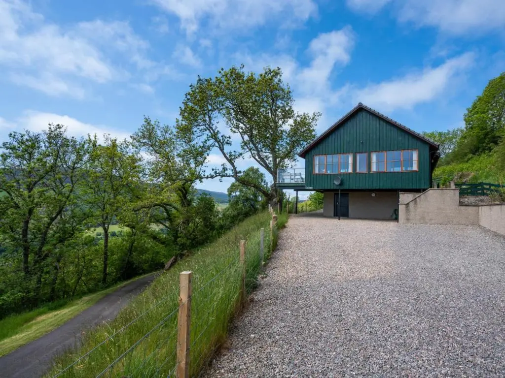 a house with a green roof on a hill at Holiday Home Achmony Green by Interhome in Drumnadrochit