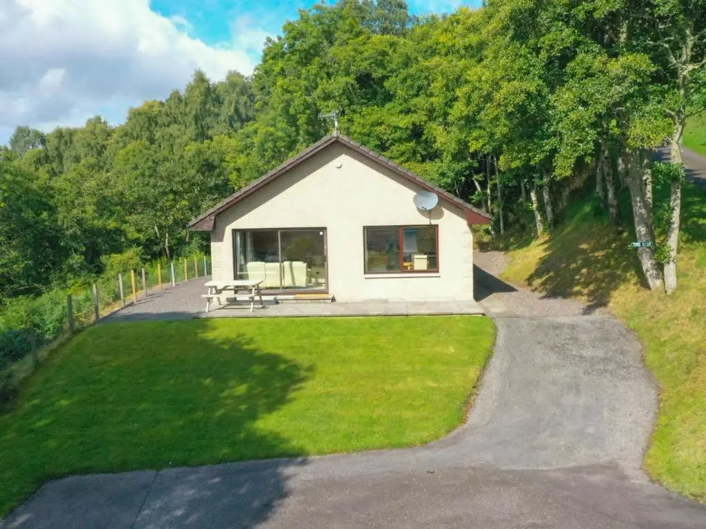 a small white house on a hill with a driveway at Holiday Home Achmony Byre by Interhome in Drumnadrochit