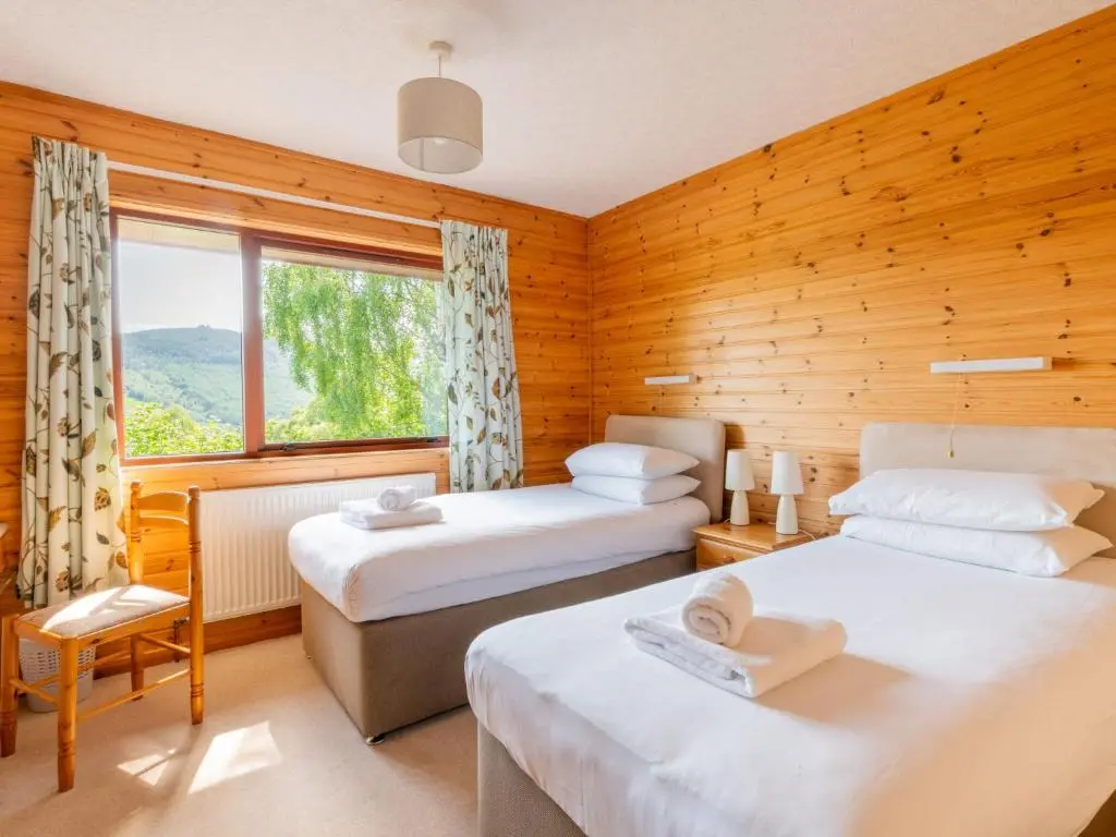 a bedroom with two beds and a window at Holiday Home Achmony Number 10 by Interhome in Drumnadrochit