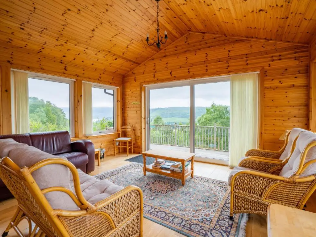 a living room with a couch and chairs and windows at Holiday Home Achmony Number 7 by Interhome in Drumnadrochit