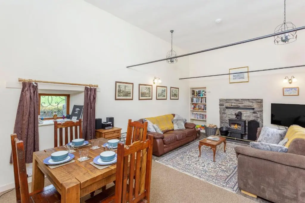 a living room with a table and a fireplace at The Old Mill in Beauly
