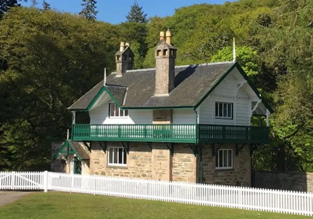 a house with a white fence in front of it at The Delnashaugh in Ballindalloch