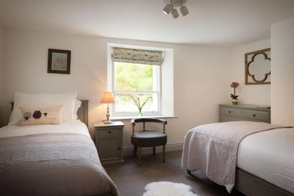 a bedroom with two beds and a window and a chair at Kincraig House - Seasgair Lodges in Kincraig