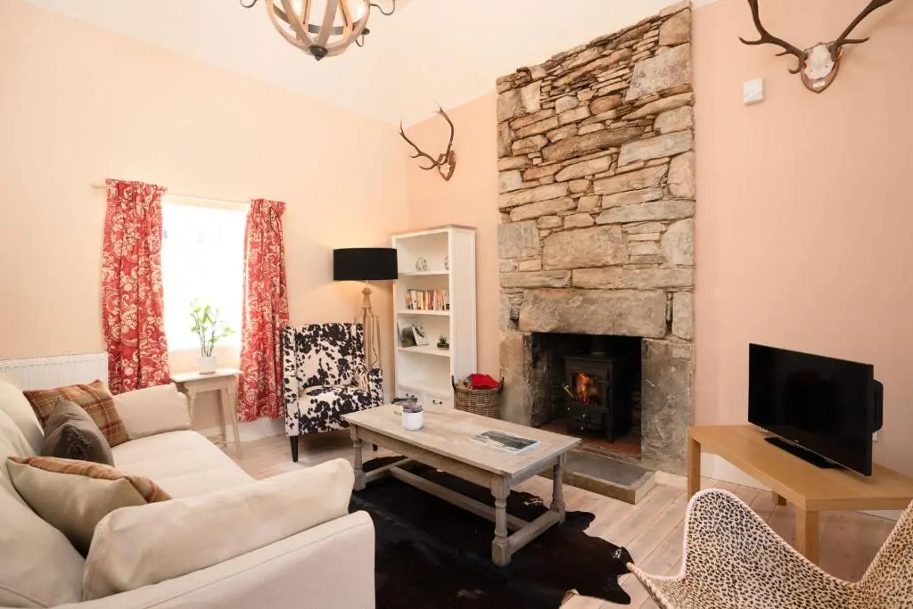 a living room with a couch and a fireplace at Kincraig House - Seasgair Lodges in Kincraig