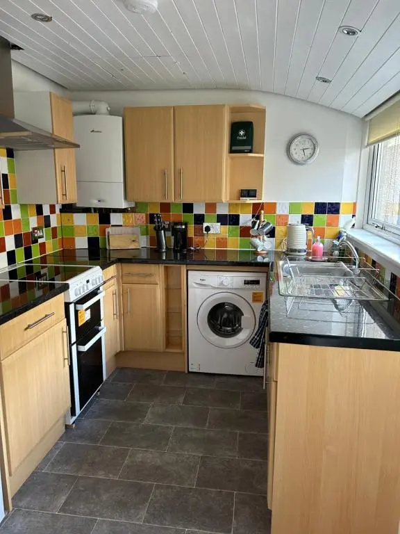 a kitchen with a washing machine and a dishwasher at Rosebery apartment-Inverness in Inverness