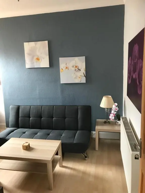 a living room with a black couch and two paintings at Rosebery apartment-Inverness in Inverness