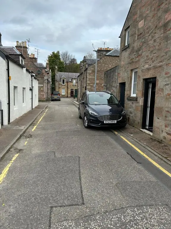 a car parked on the side of a street at Rosebery apartment-Inverness in Inverness