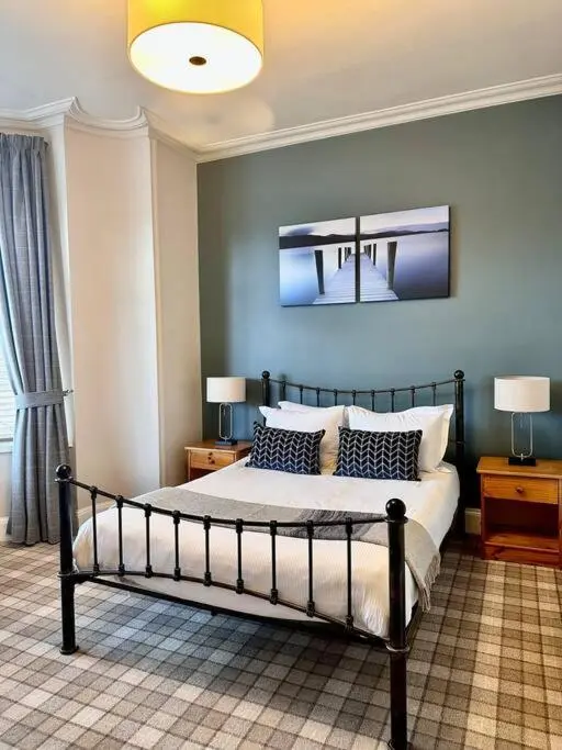 a bedroom with a bed with two night stands and two lamps at Home Sweet Home, Central in Inverness