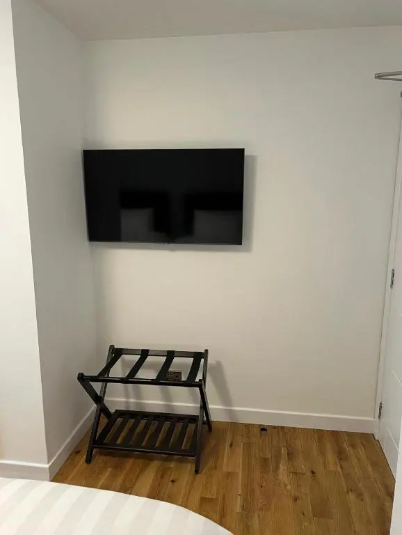 a room with a tv on a white wall at Inverness Highland Apartment in Inverness