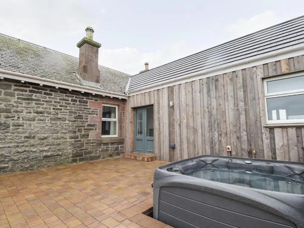 a hot tub in the courtyard of a house at Station House in Lybster