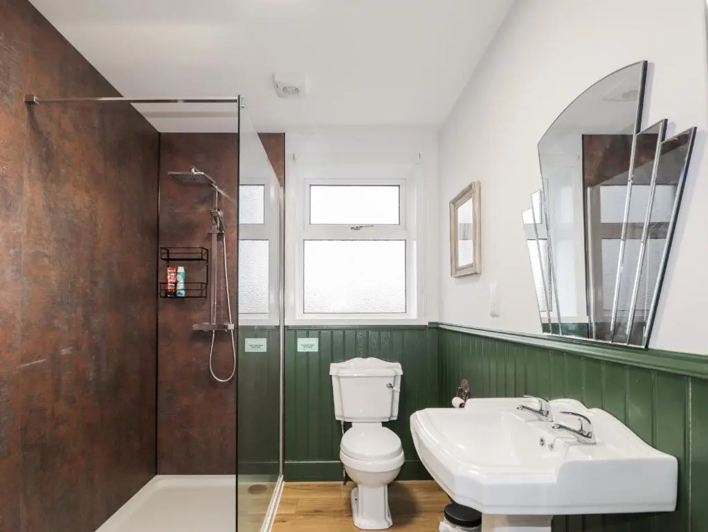 a bathroom with a toilet and a sink and a shower at Station House in Lybster
