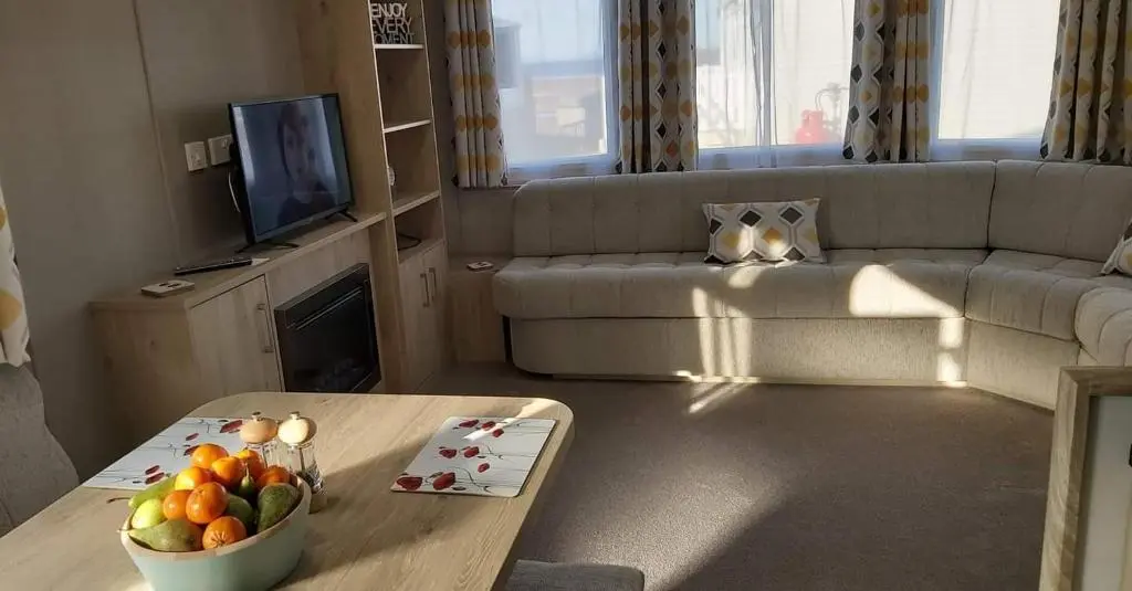 a living room with a table with a bowl of fruit at Caravan By The Sea in Elgin