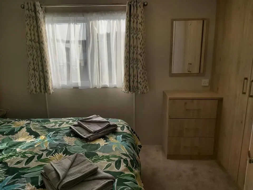 a bedroom with a bed and a window at Caravan By The Sea in Elgin
