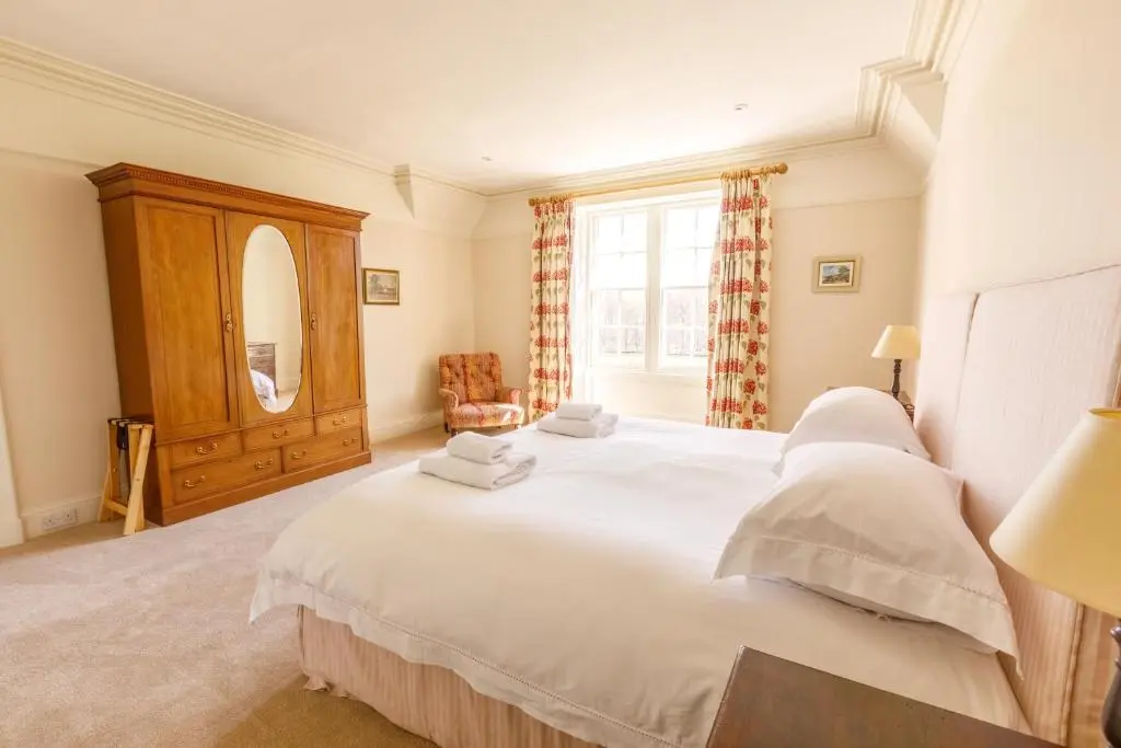 a bedroom with a large white bed and a window at Dalgheal in Evanton