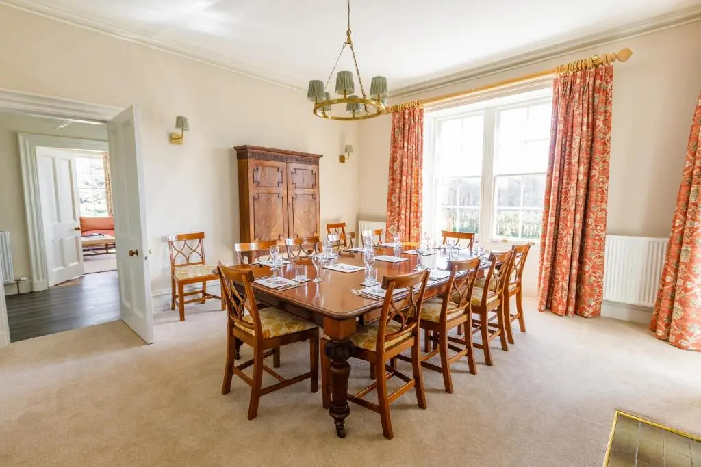 a dining room with a wooden table and chairs at Dalgheal in Evanton