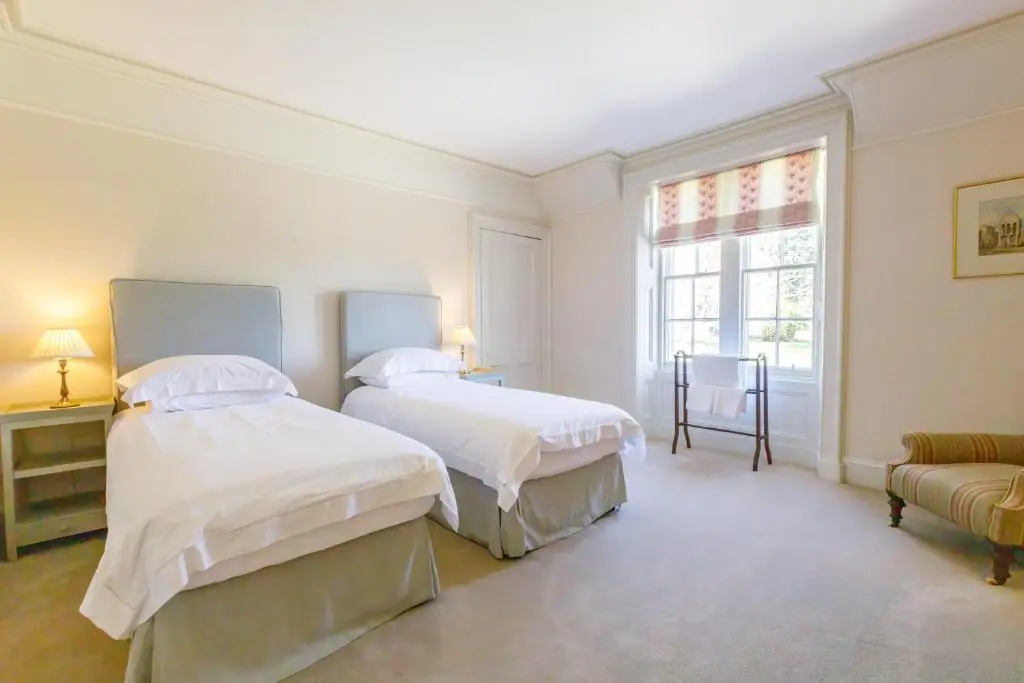 two beds in a white room with a window at Dalgheal in Evanton