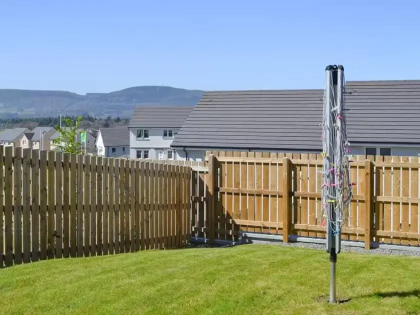 a wooden fence in a yard with an american flag at Faillie in Inverness